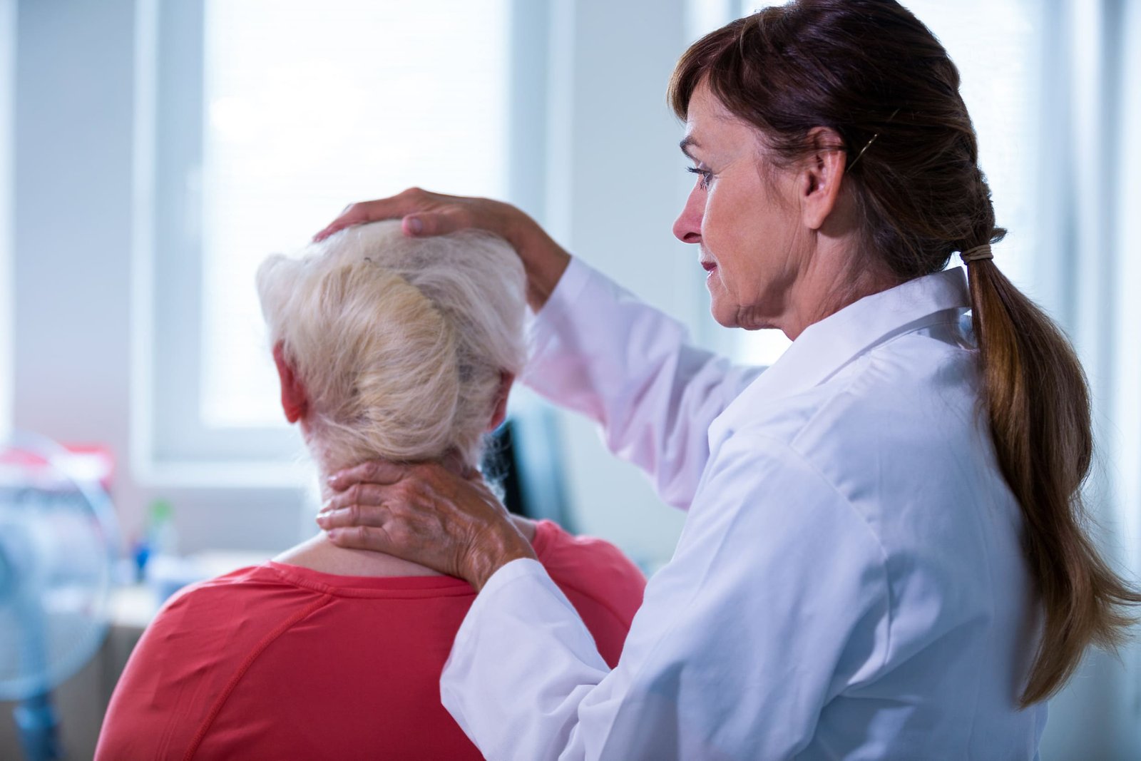 Doctor examining the back of a patient's head and neck