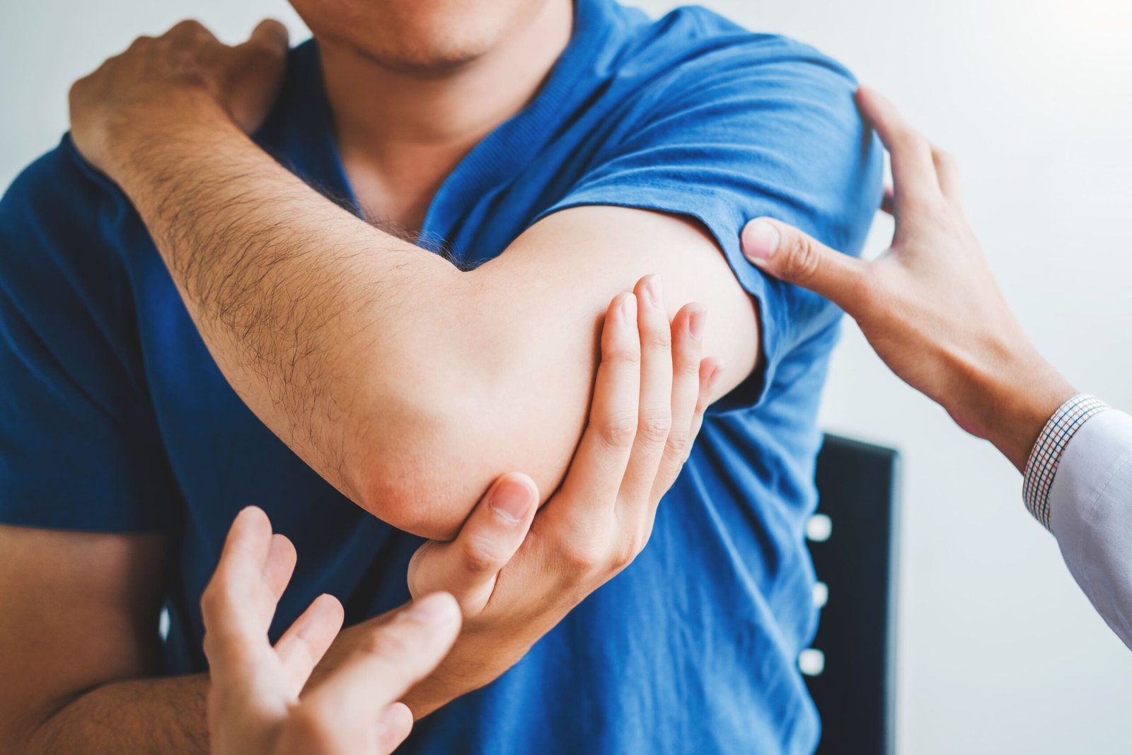 Doctor examining a patient's elbow and arm