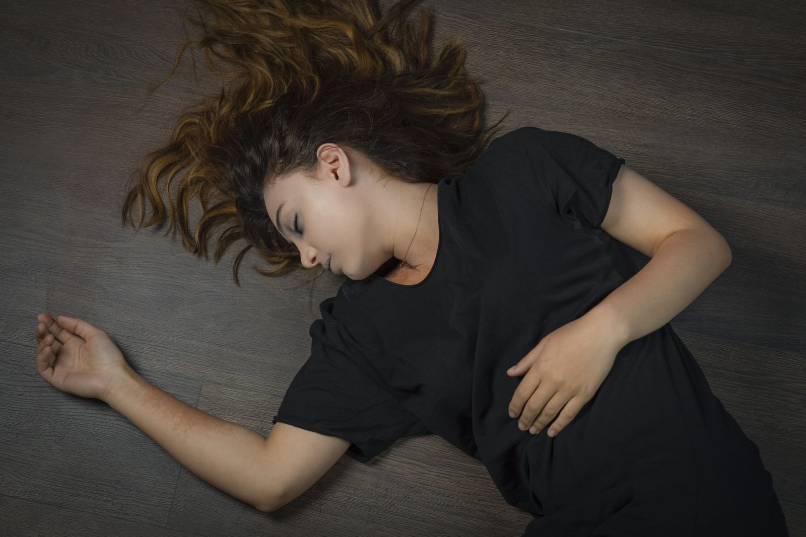 Young woman lying unconscious on the floor